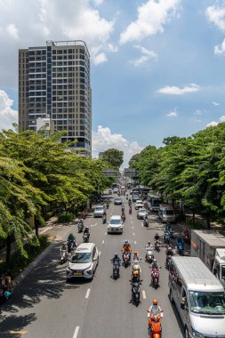 Ho Chi Minh şehri, Vietnam - 12 Ağustos 2023: Güneşli bir günde yoğun trafik ve Saygon caddesinde sayısız otel, bar ve dükkan tabelası bulunan renkli perspektif, insanlarla dolu, motosikletler