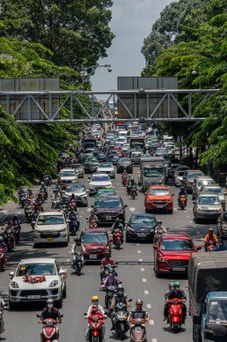 Ho Chi Minh şehri, Vietnam - 12 Ağustos 2023: Güneşli bir günde yoğun trafik ve Saygon caddesinde sayısız otel, bar ve dükkan tabelası bulunan renkli perspektif, insanlarla dolu, motosikletler