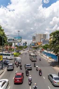 Ho Chi Minh şehri, Vietnam - 12 Ağustos 2023: Güneşli bir günde yoğun trafik ve Saygon caddesinde sayısız otel, bar ve dükkan tabelası bulunan renkli perspektif, insanlarla dolu, motosikletler