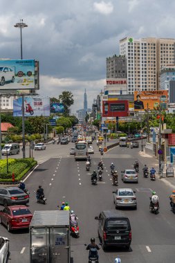 Ho Chi Minh şehri, Vietnam - 12 Ağustos 2023: Güneşli bir günde yoğun trafik ve Saygon caddesinde sayısız otel, bar ve dükkan tabelası bulunan renkli perspektif, insanlarla dolu, motosikletler