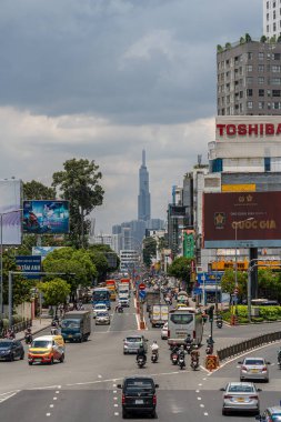 Ho Chi Minh şehri, Vietnam - 12 Ağustos 2023: Güneşli bir günde yoğun trafik ve Saygon caddesinde sayısız otel, bar ve dükkan tabelası bulunan renkli perspektif, insanlarla dolu, motosikletler