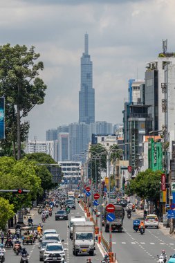 Ho Chi Minh şehri, Vietnam - 12 Ağustos 2023: Güneşli bir günde yoğun trafik ve Saygon caddesinde sayısız otel, bar ve dükkan tabelası bulunan renkli perspektif, insanlarla dolu, motosikletler