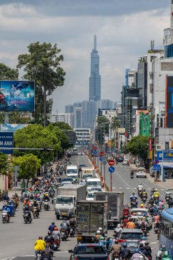 Ho Chi Minh şehri, Vietnam - 12 Ağustos 2023: Güneşli bir günde yoğun trafik ve Saygon caddesinde sayısız otel, bar ve dükkan tabelası bulunan renkli perspektif, insanlarla dolu, motosikletler