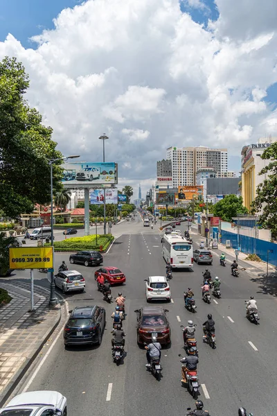Ho Chi Minh şehri, Vietnam - 12 Ağustos 2023: Güneşli bir günde yoğun trafik ve Saygon caddesinde sayısız otel, bar ve dükkan tabelası bulunan renkli perspektif, insanlarla dolu, motosikletler