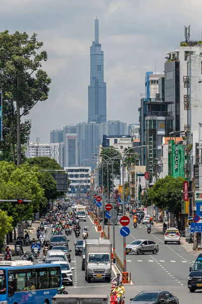 Ho Chi Minh şehri, Vietnam - 12 Ağustos 2023: Güneşli bir günde yoğun trafik ve Saygon caddesinde sayısız otel, bar ve dükkan tabelası bulunan renkli perspektif, insanlarla dolu, motosikletler