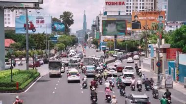 Ho Chi Minh şehri, Vietnam - 12 Ağustos 2023: Güneşli bir günde yoğun trafik ve Saygon caddesinde sayısız otel, bar ve dükkan tabelası bulunan renkli perspektif, insanlarla dolu, motosikletler