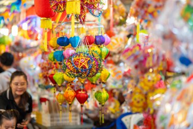 Sonbahar Festivali sırasında Ho Chi Minh City, Vietnam sokaklarında asılı duran renkli fenerler. Fotoğraflardaki Çince, para ve mutluluk demektir. Seçici odak.