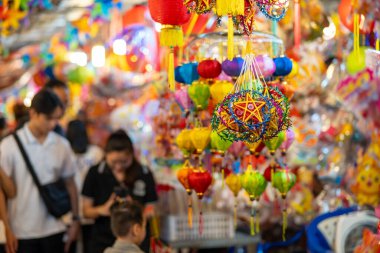 Sonbahar Festivali sırasında Ho Chi Minh City, Vietnam sokaklarında asılı duran renkli fenerler. Fotoğraflardaki Çince, para ve mutluluk demektir. Seçici odak.