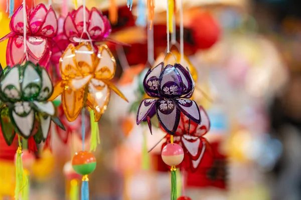 stock image Decorated colorful lanterns hanging on a stand in the streets in Ho Chi Minh City, Vietnam during Mid Autumn Festival. Chinese language in photos mean money and happiness. Selective focus.