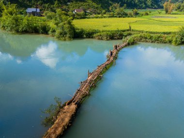 Phong Nam Vadisi 'ndeki hava manzarası çiftçiler, nehir, doğa, yeşil pirinç tarlaları ile Vietnam' ın Cao Bang eyaletindeki evlerine pirinç taşıyorlar. Seyahat ve manzara konsepti.