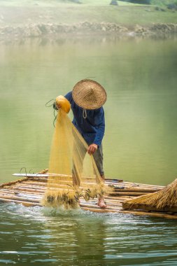 Tra Linh, Cao Bang vilayetindeki Thung Dağı 'nda nehirde balık tutan balıkçıları göl, bulutlu, doğa ile Vietnam' da görüyoruz. Seyahat ve manzara konsepti.