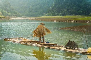 Tra Linh, Cao Bang vilayetindeki Thung Dağı 'nda nehirde balık tutan balıkçıları göl, bulutlu, doğa ile Vietnam' da görüyoruz. Seyahat ve manzara konsepti.