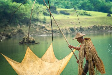 Tra Linh, Cao Bang vilayetindeki Thung Dağı 'nda nehirde balık tutan balıkçıları göl, bulutlu, doğa ile Vietnam' da görüyoruz. Seyahat ve manzara konsepti.