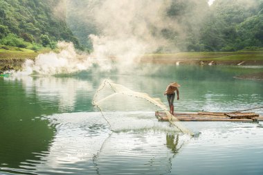 Tra Linh, Cao Bang vilayetindeki Thung Dağı 'nda nehirde balık tutan balıkçıları göl, bulutlu, doğa ile Vietnam' da görüyoruz. Seyahat ve manzara konsepti.