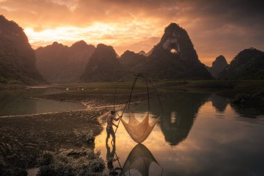 Tra Linh, Cao Bang vilayetindeki Thung Dağı 'nda nehirde balık tutan balıkçıları göl, bulutlu, doğa ile Vietnam' da görüyoruz. Seyahat ve manzara konsepti.