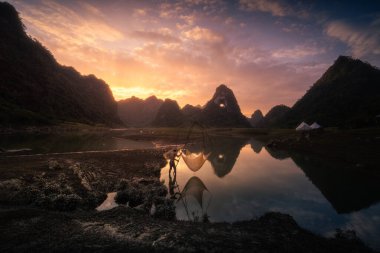 Tra Linh, Cao Bang vilayetindeki Thung Dağı 'nda nehirde balık tutan balıkçıları göl, bulutlu, doğa ile Vietnam' da görüyoruz. Seyahat ve manzara konsepti.