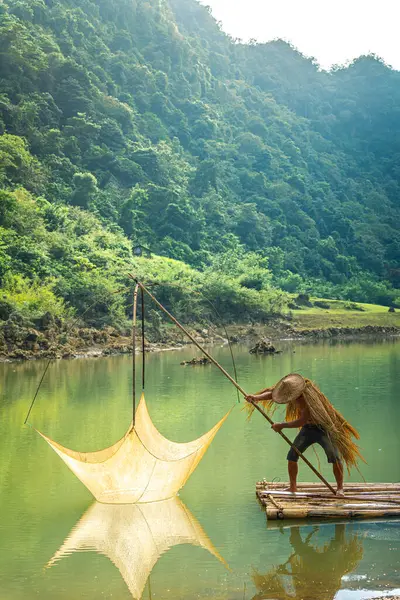 Tra Linh, Cao Bang vilayetindeki Thung Dağı 'nda nehirde balık tutan balıkçıları göl, bulutlu, doğa ile Vietnam' da görüyoruz. Seyahat ve manzara konsepti.