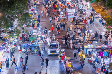 Dalat City, Vietnam - 01 Aralık 2023: Da Lat pazarında gece trafiği. Kalabalık atmosfer, soğuk havada sokak yemekleriyle beslenen gezginler, pazar yerinde kalabalık.
