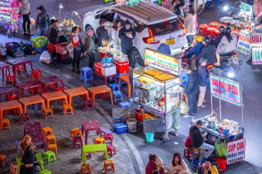Dalat City, Vietnam - 01 Aralık 2023: Da Lat pazarında gece trafiği. Kalabalık atmosfer, soğuk havada sokak yemekleriyle beslenen gezginler, pazar yerinde kalabalık.