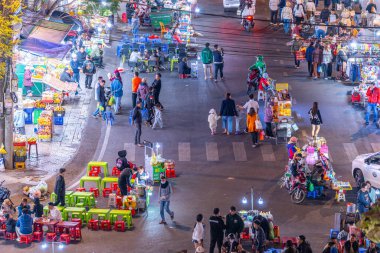 Dalat City, Vietnam - 01 Aralık 2023: Da Lat pazarında gece trafiği. Kalabalık atmosfer, soğuk havada sokak yemekleriyle beslenen gezginler, pazar yerinde kalabalık.