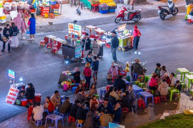 Dalat City, Vietnam - 01 Aralık 2023: Da Lat pazarında gece trafiği. Kalabalık atmosfer, soğuk havada sokak yemekleriyle beslenen gezginler, pazar yerinde kalabalık.