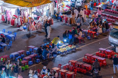 Dalat City, Vietnam - 01 Aralık 2023: Da Lat pazarında gece trafiği. Kalabalık atmosfer, soğuk havada sokak yemekleriyle beslenen gezginler, pazar yerinde kalabalık.