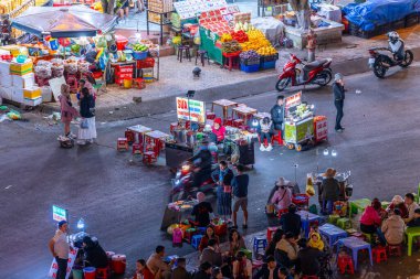 Dalat City, Vietnam - 01 Aralık 2023: Da Lat pazarında gece trafiği. Kalabalık atmosfer, soğuk havada sokak yemekleriyle beslenen gezginler, pazar yerinde kalabalık.