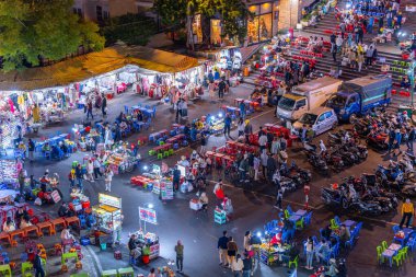 Dalat City, Vietnam - 01 Aralık 2023: Da Lat pazarında gece trafiği. Kalabalık atmosfer, soğuk havada sokak yemekleriyle beslenen gezginler, pazar yerinde kalabalık.