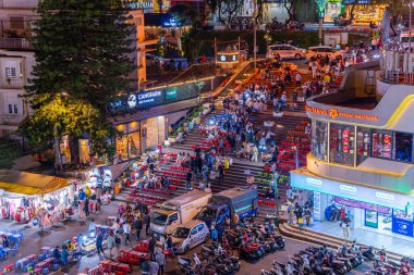 Dalat City, Vietnam - 01 Aralık 2023: Da Lat pazarında gece trafiği. Kalabalık atmosfer, soğuk havada sokak yemekleriyle beslenen gezginler, pazar yerinde kalabalık.
