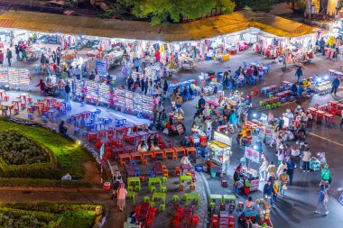 Dalat City, Vietnam - 01 Aralık 2023: Da Lat pazarında gece trafiği. Kalabalık atmosfer, soğuk havada sokak yemekleriyle beslenen gezginler, pazar yerinde kalabalık.