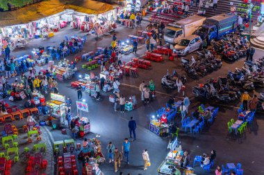 Dalat City, Vietnam - 01 Aralık 2023: Da Lat pazarında gece trafiği. Kalabalık atmosfer, soğuk havada sokak yemekleriyle beslenen gezginler, pazar yerinde kalabalık.