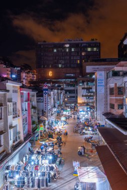 Dalat City, Vietnam - 01 Aralık 2023: Da Lat pazarında gece trafiği. Kalabalık atmosfer, soğuk havada sokak yemekleriyle beslenen gezginler, pazar yerinde kalabalık.