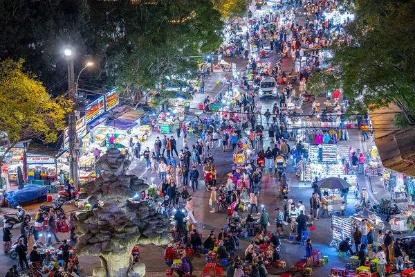 Dalat City, Vietnam - 01 Aralık 2023: Da Lat pazarında gece trafiği. Kalabalık atmosfer, soğuk havada sokak yemekleriyle beslenen gezginler, pazar yerinde kalabalık.