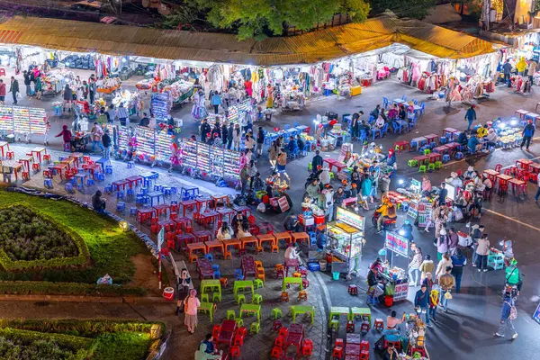 Dalat City, Vietnam - 01 Aralık 2023: Da Lat pazarında gece trafiği. Kalabalık atmosfer, soğuk havada sokak yemekleriyle beslenen gezginler, pazar yerinde kalabalık.