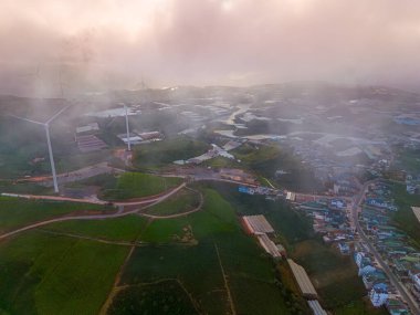 Sabahleyin, Da Lat şehri, Cau Dat, Lam Dong 'da güzel bir manzara. Çay tepesinde rüzgar enerjisi, çayın yamacında sabah manzarası güzel vadinin altındaki sisli dağlarda ekilmiş.
