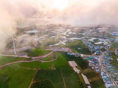 Sabahleyin, Da Lat şehri, Cau Dat, Lam Dong 'da güzel bir manzara. Çay tepesinde rüzgar enerjisi, çayın yamacında sabah manzarası güzel vadinin altındaki sisli dağlarda ekilmiş.