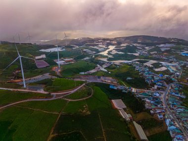 Sabahleyin, Da Lat şehri, Cau Dat, Lam Dong 'da güzel bir manzara. Çay tepesinde rüzgar enerjisi, çayın yamacında sabah manzarası güzel vadinin altındaki sisli dağlarda ekilmiş.