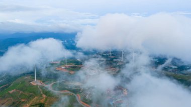 Sabahleyin, Da Lat şehri, Cau Dat, Lam Dong 'da güzel bir manzara. Çay tepesinde rüzgar enerjisi, çayın yamacında sabah manzarası güzel vadinin altındaki sisli dağlarda ekilmiş.