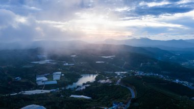 Sabahleyin, Da Lat şehri, Cau Dat, Lam Dong 'da güzel bir manzara. Çay tepesinde rüzgar enerjisi, çayın yamacında sabah manzarası güzel vadinin altındaki sisli dağlarda ekilmiş.