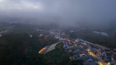 Sabahleyin, Da Lat şehri, Cau Dat, Lam Dong 'da güzel bir manzara. Çay tepesinde rüzgar enerjisi, çayın yamacında sabah manzarası güzel vadinin altındaki sisli dağlarda ekilmiş.