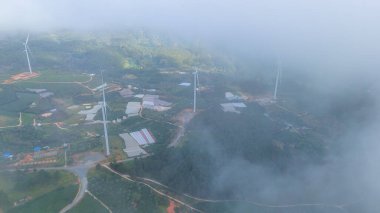 Sabahleyin, Da Lat şehri, Cau Dat, Lam Dong 'da güzel bir manzara. Çay tepesinde rüzgar enerjisi, çayın yamacında sabah manzarası güzel vadinin altındaki sisli dağlarda ekilmiş.