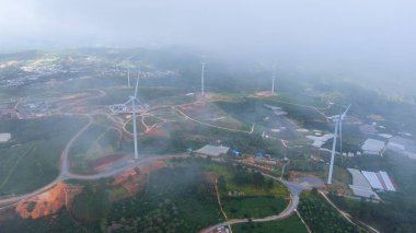 Sabahleyin, Da Lat şehri, Cau Dat, Lam Dong 'da güzel bir manzara. Çay tepesinde rüzgar enerjisi, çayın yamacında sabah manzarası güzel vadinin altındaki sisli dağlarda ekilmiş.