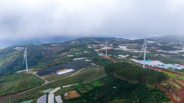 Sabahleyin, Da Lat şehri, Cau Dat, Lam Dong 'da güzel bir manzara. Çay tepesinde rüzgar enerjisi, çayın yamacında sabah manzarası güzel vadinin altındaki sisli dağlarda ekilmiş.