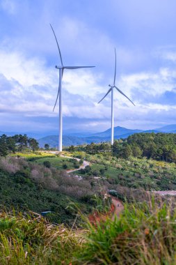 Sabahleyin, Da Lat şehri, Cau Dat, Lam Dong 'da güzel bir manzara. Çay tepesinde rüzgar enerjisi, çayın yamacında sabah manzarası güzel vadinin altındaki sisli dağlarda ekilmiş.