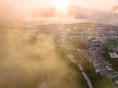 Sabahleyin, Da Lat şehri, Cau Dat, Lam Dong 'da güzel bir manzara. Çay tepesinde rüzgar enerjisi, çayın yamacında sabah manzarası güzel vadinin altındaki sisli dağlarda ekilmiş.