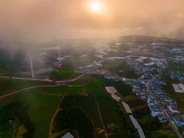 Sabahleyin, Da Lat şehri, Cau Dat, Lam Dong 'da güzel bir manzara. Çay tepesinde rüzgar enerjisi, çayın yamacında sabah manzarası güzel vadinin altındaki sisli dağlarda ekilmiş.