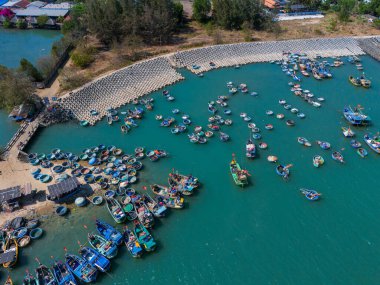 Vung Tau şehrindeki bir balıkçı köyünün havadan görünüşü. Tsunami korumalı bir balıkçı limanı beton bloklar. Şehir manzarası ve denizde geleneksel tekneler. Seyahat ve manzara konsepti