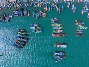 Vung Tau şehrindeki bir balıkçı köyünün havadan görünüşü. Tsunami korumalı bir balıkçı limanı beton bloklar. Şehir manzarası ve denizde geleneksel tekneler. Seyahat ve manzara konsepti