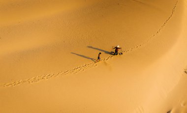 Köylü bir kadının havadan görünüşü, Vietnam 'ın Ninh Thuan eyaletinde kum tepeleri üzerinde bambu bir çerçeve taşır. Vietnam 'da seyahat ve fotoğraf için en güzel yerlerden biridir.