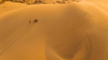 Köylü bir kadının havadan görünüşü, Vietnam 'ın Ninh Thuan eyaletinde kum tepeleri üzerinde bambu bir çerçeve taşır. Vietnam 'da seyahat ve fotoğraf için en güzel yerlerden biridir.